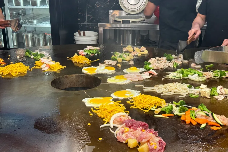 Customized noodles, proteins and vegetables cooking fresh on the Mongolian grill